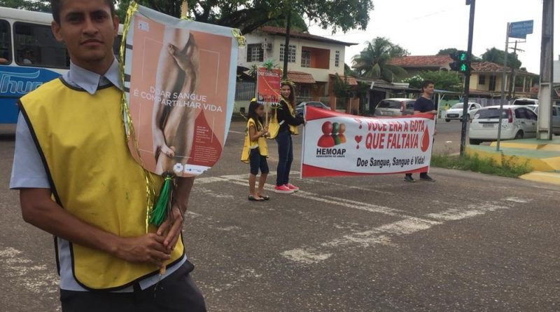 Voluntários com faixas em esquina para convocar pessoas para a doação — Foto: Ugor Feio/G1